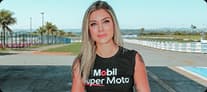 Vans Faria usando camiseta Mobil Super Moto em autódromo com pista e gramado ao fundo.