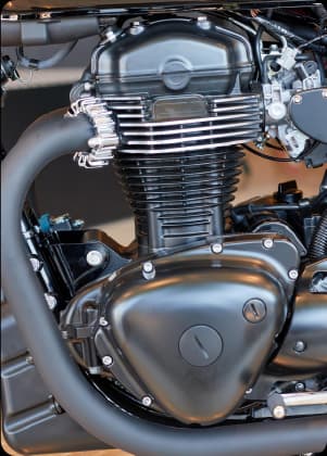 Motor limpo de motocicleta em close-up, com destaque para componentes metálicos e acabamento preto.