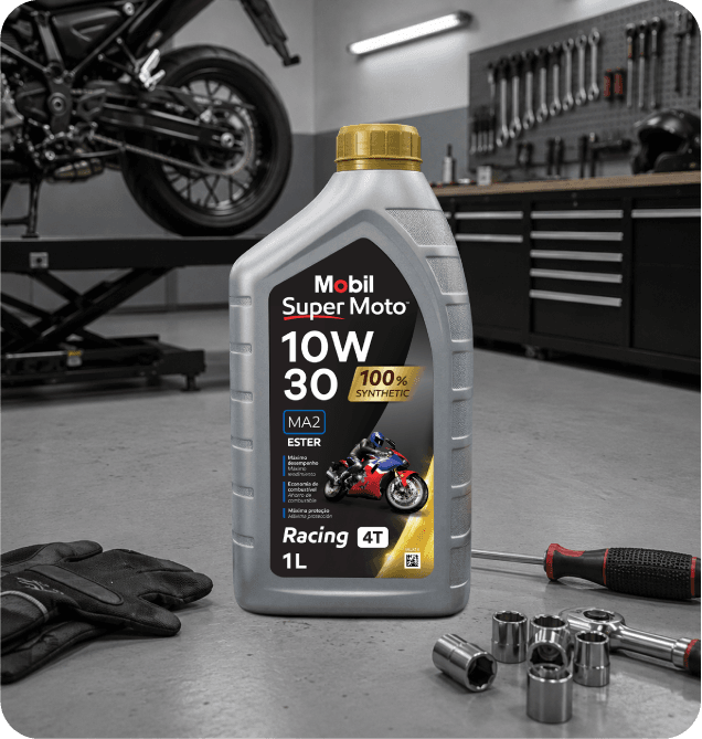 Embalagem de óleo Mobil Super Moto 10W-30 em oficina, com motocicleta e ferramentas ao fundo.