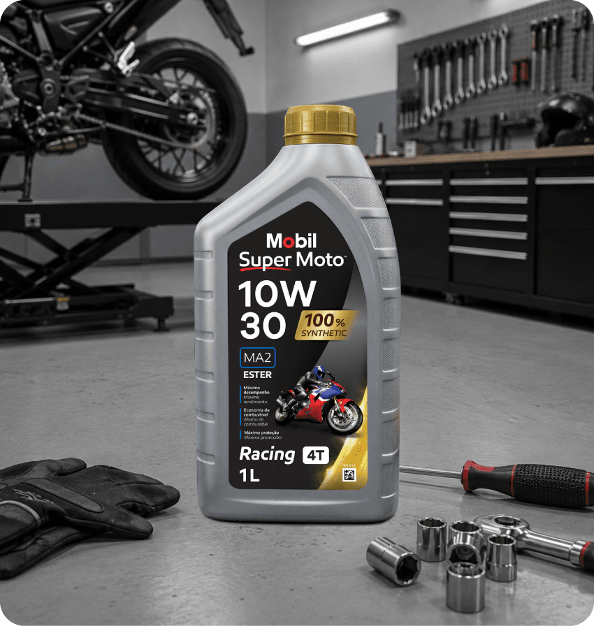 Embalagem de óleo Mobil Super Moto 10W-30 em oficina, com motocicleta e ferramentas ao fundo.
