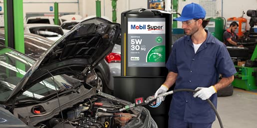 Mecânico abastecendo o motor de um carro com óleo Mobil Super em oficina automotiva.