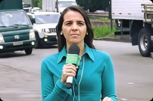 Paula Toco sorrindo usando camisa polo azul com logo da Mobil em fundo escuro.