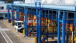 Caminhão passando por manutenção em uma usina de cores azul, amarelo e vermlho, ilustrando o uso dos lubrificantes Mobil